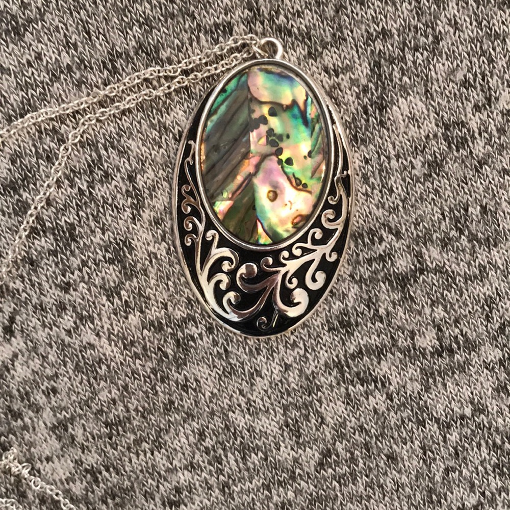 Abalone and silver look pendant and chain .